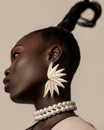 Elegant profile of a woman wearing large leaf-shaped earrings, showcasing fashion and style.