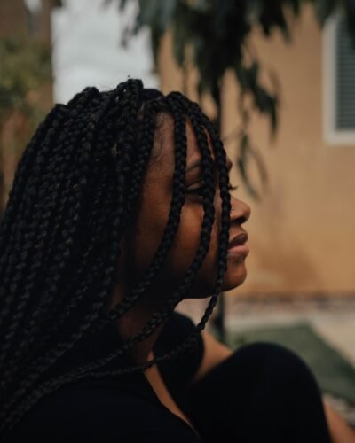 person with braided hair wearing black shirt