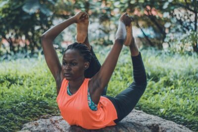 A woman practicing a yoga pose outdoors, emphasizing flexibility and fitness.