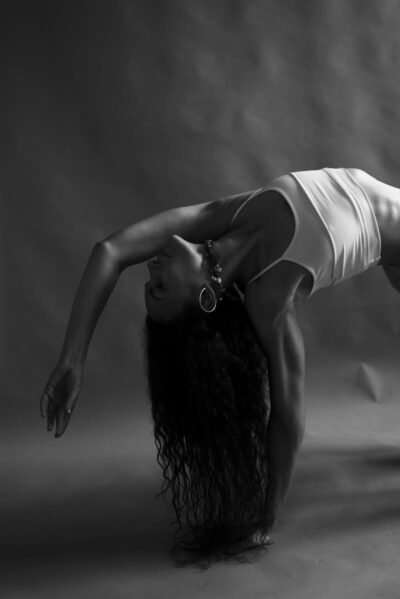Black and white photo capturing a woman in a graceful yoga pose, highlighting wellness and balance.