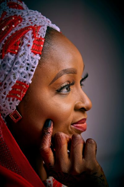A woman with a headscarf looks thoughtfully.