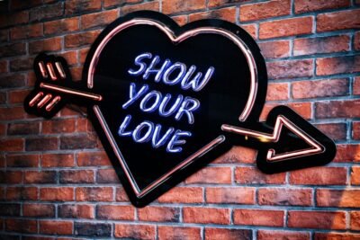 A neon heart says "show your love."