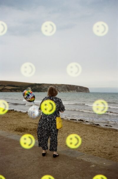 Woman with balloons walks on a beach