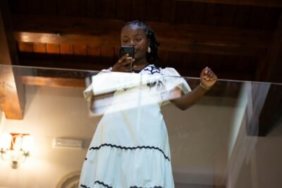 A woman in a white dress holding a cell phone