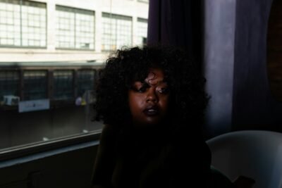 woman in black jacket sitting on white chair