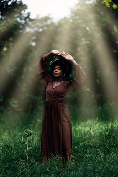 A woman in a brown dress standing in a field