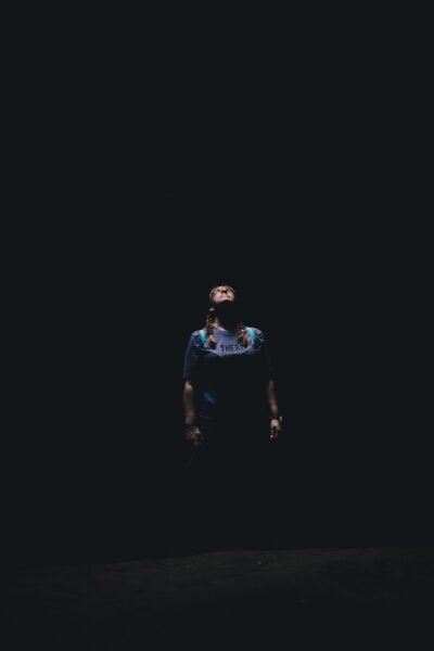 a man standing in the dark with his eyes closed