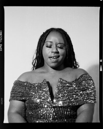 A woman with braided hair wearing a sparkly dress