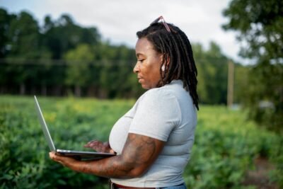 Woman using a laptop in a field