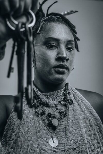 Person with dreadlocks holds antique keys