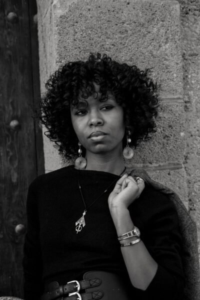 Stylish black and white portrait of a woman against a stone wall in Rabat.