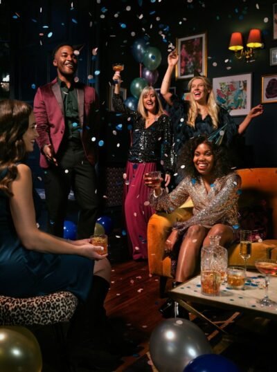 a group of people celebrating with confetti and balloons